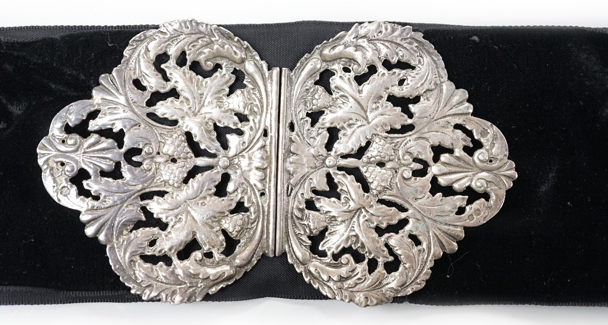 A late Victorian pierced silver belt buckle, on a black sash belt, James Deakin & Sons, Chester, 1895 (a.f.), buckle 13cm.